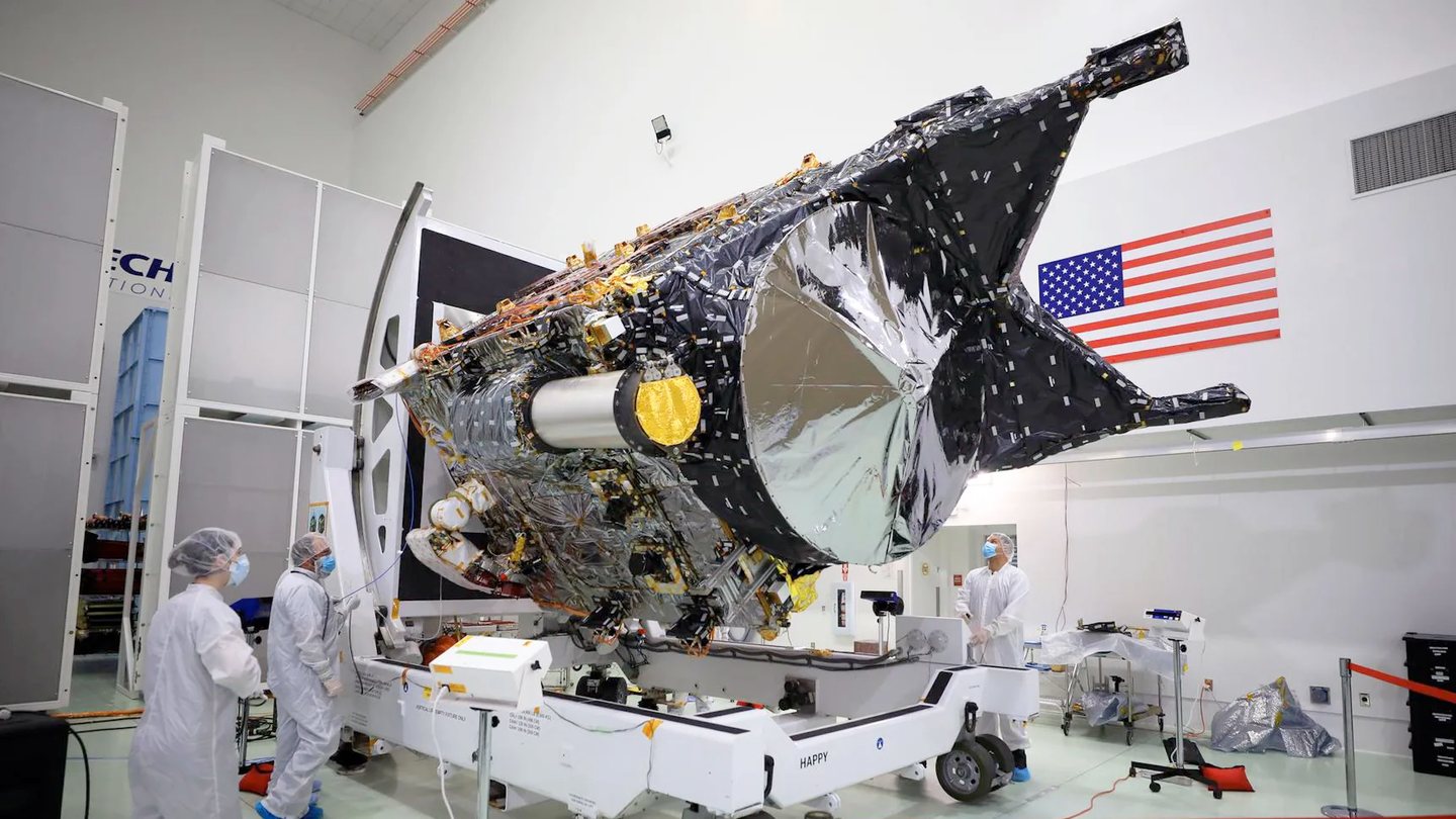 NASA Psyche spacecraft surrounded by engineers in lab